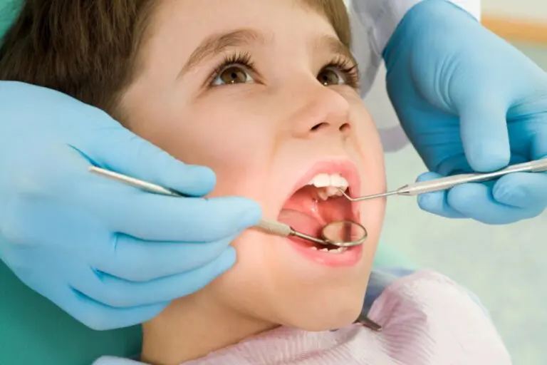 During a checkup at Lake Sammamish Kids Dentistry in Sammamish, WA, a dentist examines a child's teeth with dental tools - Dental Sealants for Kids in Sammamish, WA.