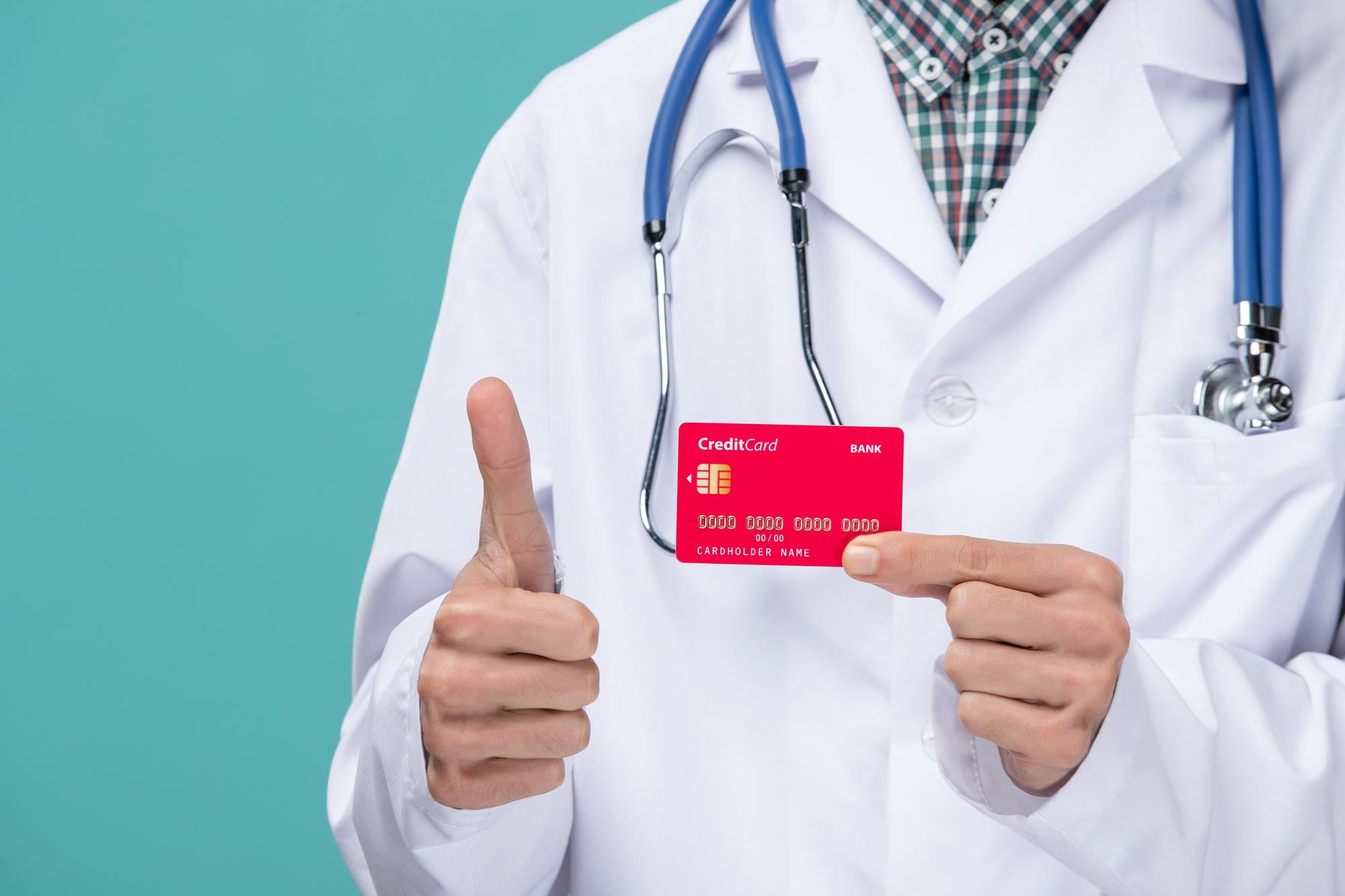 At Lake Sammamish Kids Dentistry - Pediatric Dentist in Sammamish WA, a person in a white lab coat with a stethoscope demonstrates how to use your ProviderOne Card by holding a red credit card and giving a thumbs-up.