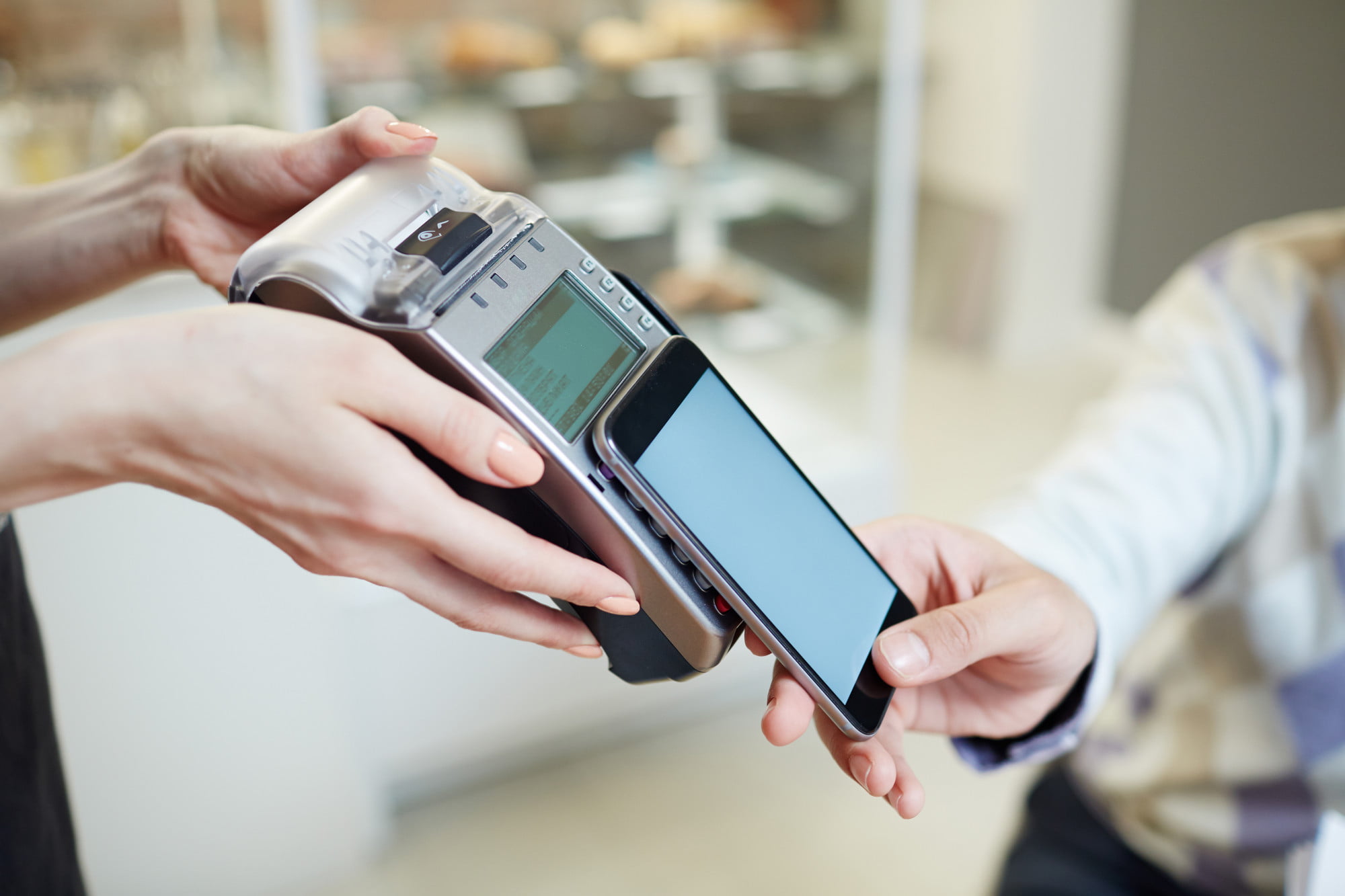 At Lake Sammamish Kids Dentistry - Pediatric Dentist in Sammamish WA, a person uses a smartphone for contactless payment at a terminal, highlighting the convenience of flexible payment plans.