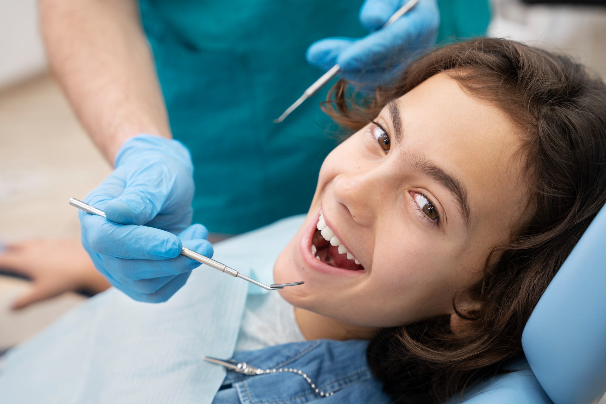 At Lake Sammamish Kids Dentistry - Pediatric Dentist in Sammamish WA, a child smiles in the dental chair as a dentist with blue gloves gently examines their teeth. Apple Health covers sedation, ensuring visits remain comfortable and stress-free for young patients.