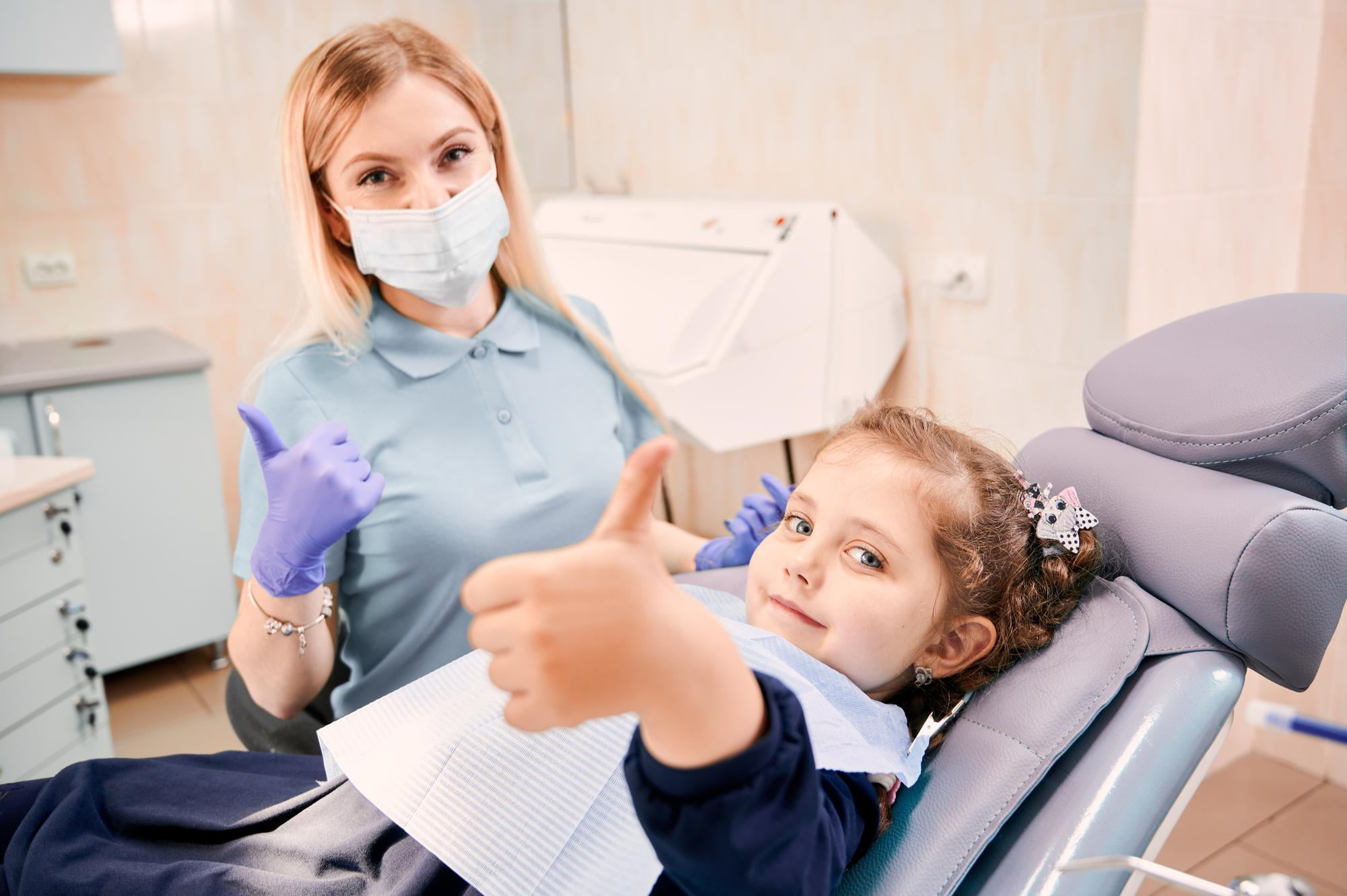 At Lake Sammamish Kids Dentistry - Pediatric Dentist in Sammamish WA, a dentist and young patient share smiles and a thumbs up in the dental chair—Apple Health also covers laser procedures for an improved visit.