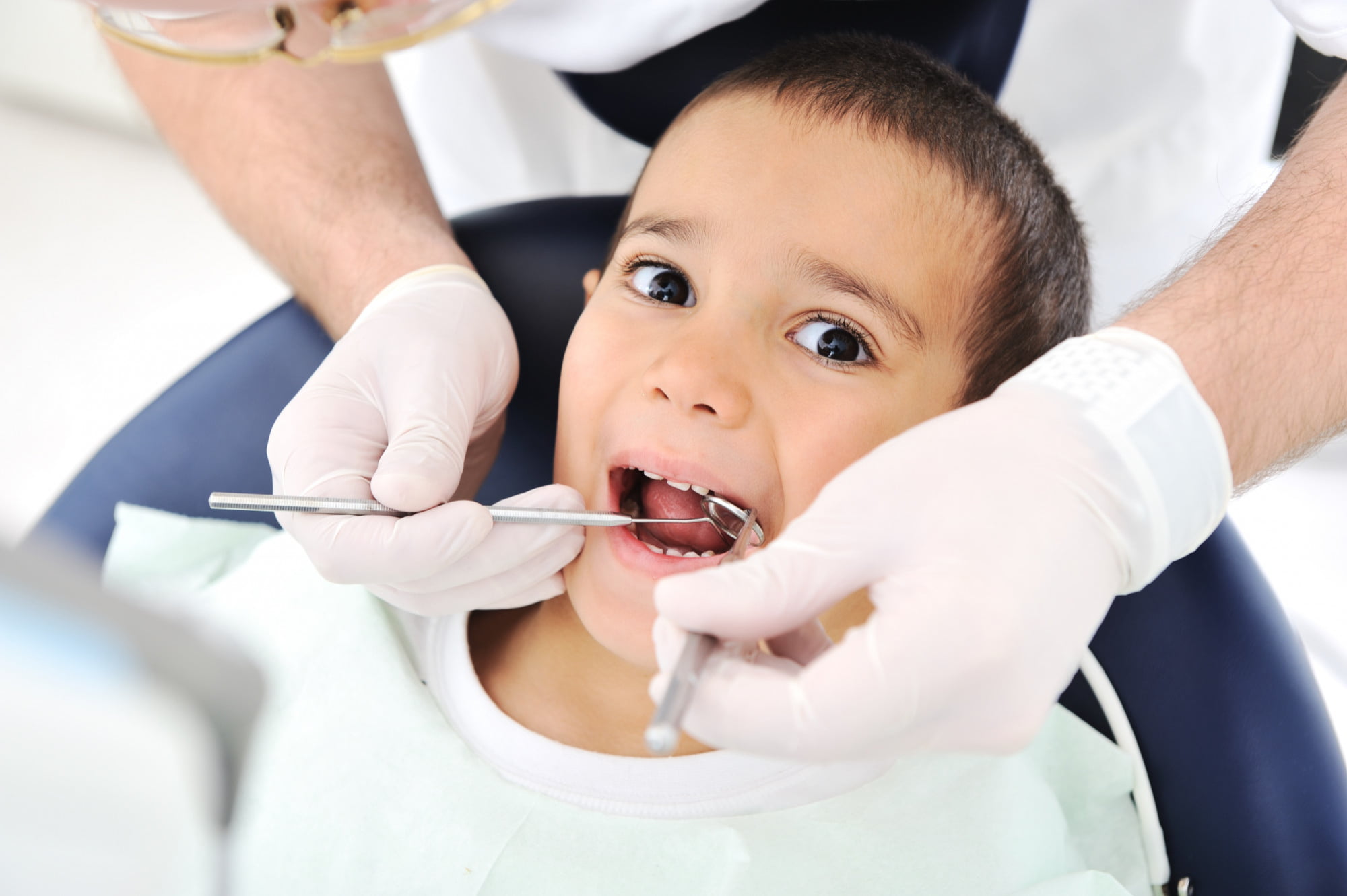 At Lake Sammamish Kids Dentistry - Pediatric Dentist in Sammamish WA, a dentist gently examines the teeth of a child with Autism Spectrum Disorder, offering specialized dental care.