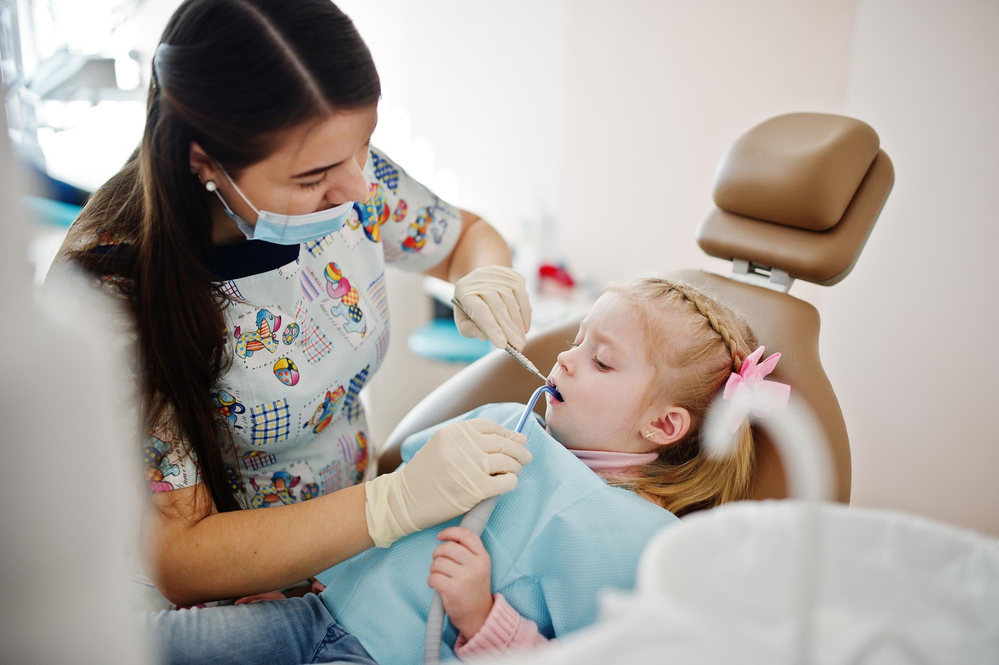 At Lake Sammamish Kids Dentistry - Pediatric Dentist in Sammamish, WA, a dentist examines a young girl's teeth during restorative dental care—ensuring kids’ smiles stay healthy with services covered by Apple Health.