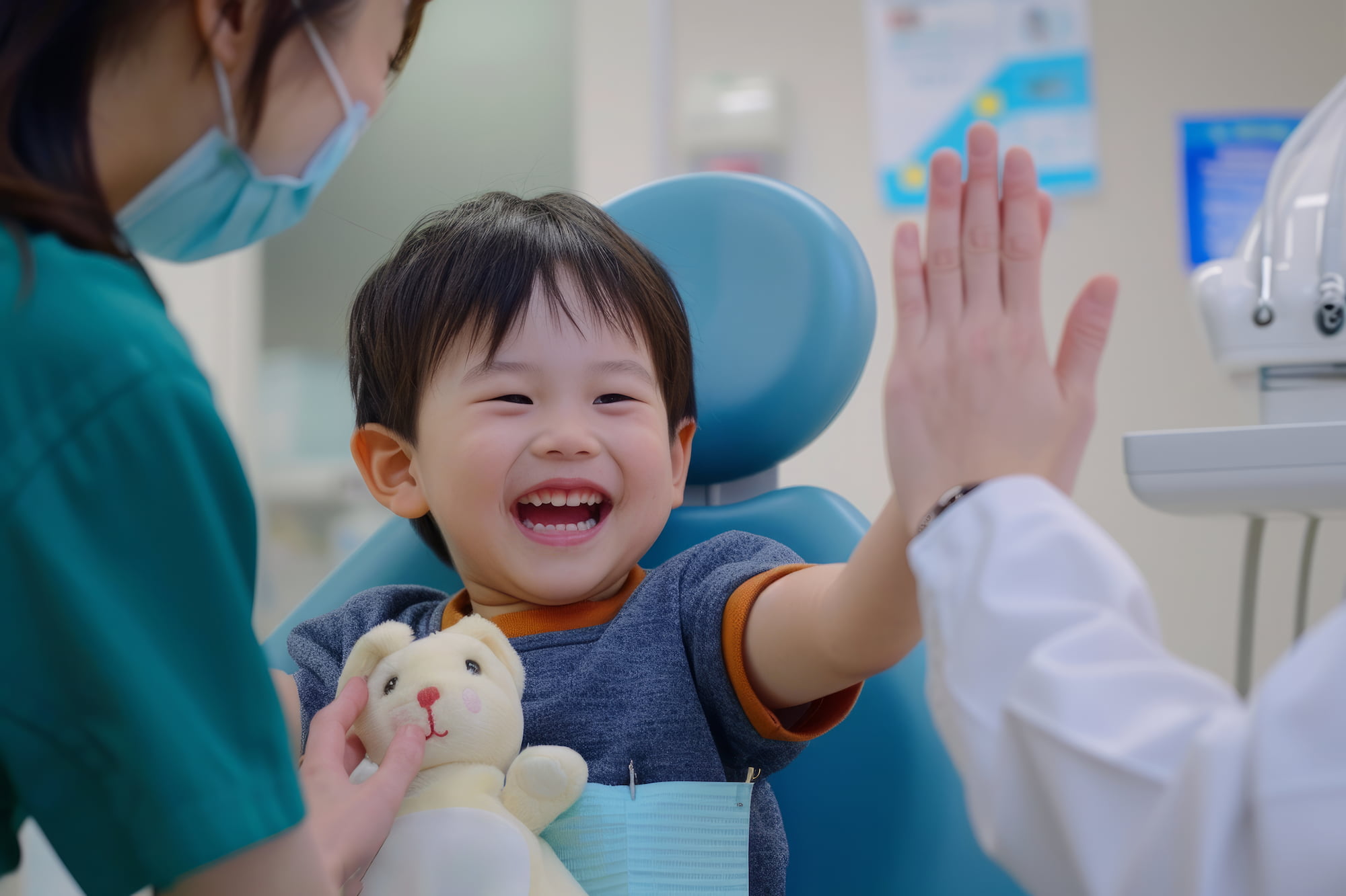 At Lake Sammamish Kids Dentistry - Pediatric Dentist in Sammamish WA, a young child confidently smiles and gives a high-five to a healthcare worker, holding a stuffed toy—thanks to parent support and thorough visit preparation.